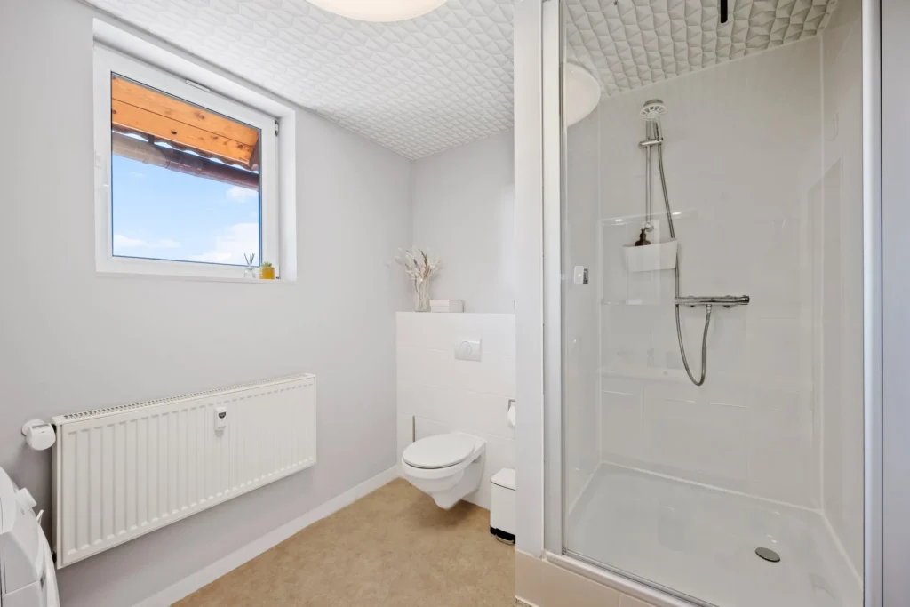 Badeværelse med bruser og toilet